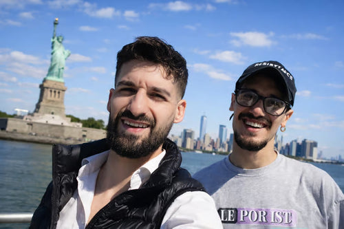 Guests on the waterfront with Statue of Liberty and Manhattan skyline behind them
