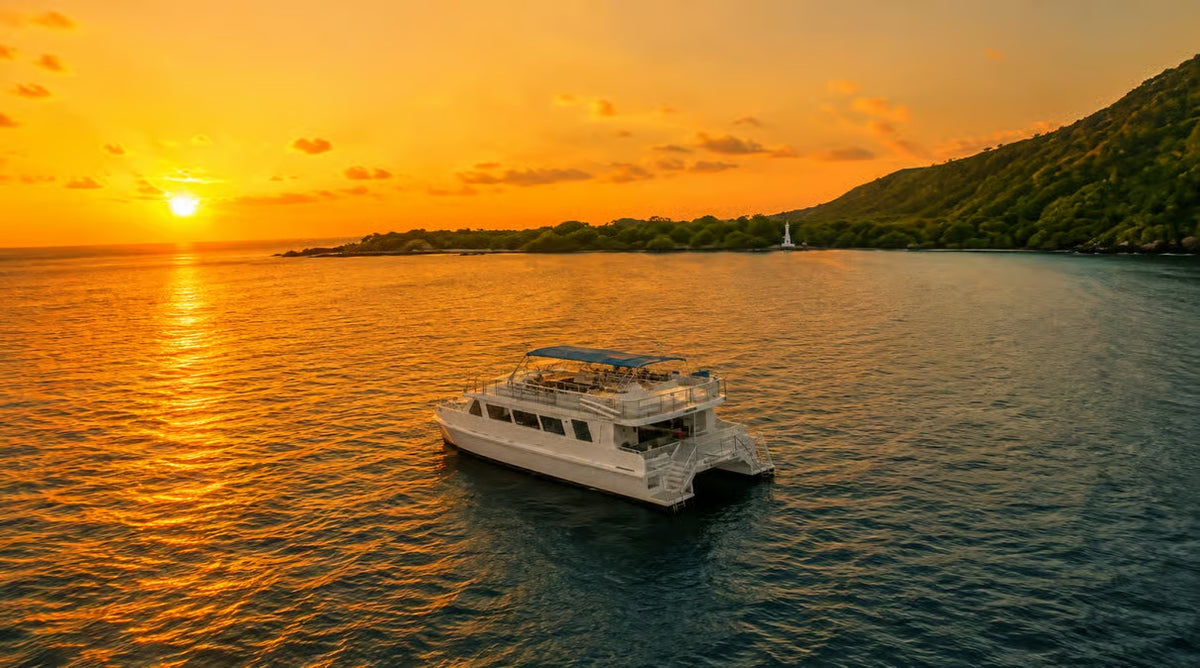 Dinner cruise catamaran sailing along the Kona coastline at golden hour