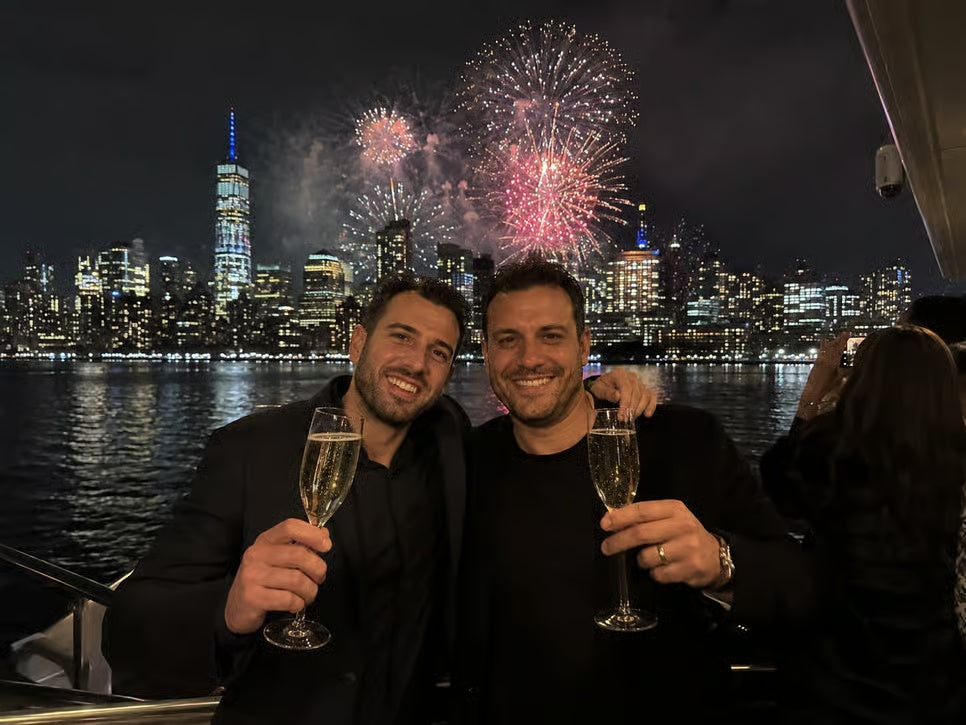 Two guests toasting with champagne during New York Harbor New Year's Eve fireworks cruise