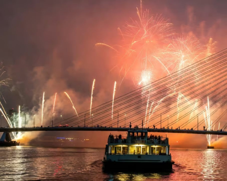 Fireworks illuminating the Rotterdam Erasmus Bridge above a boat on the river