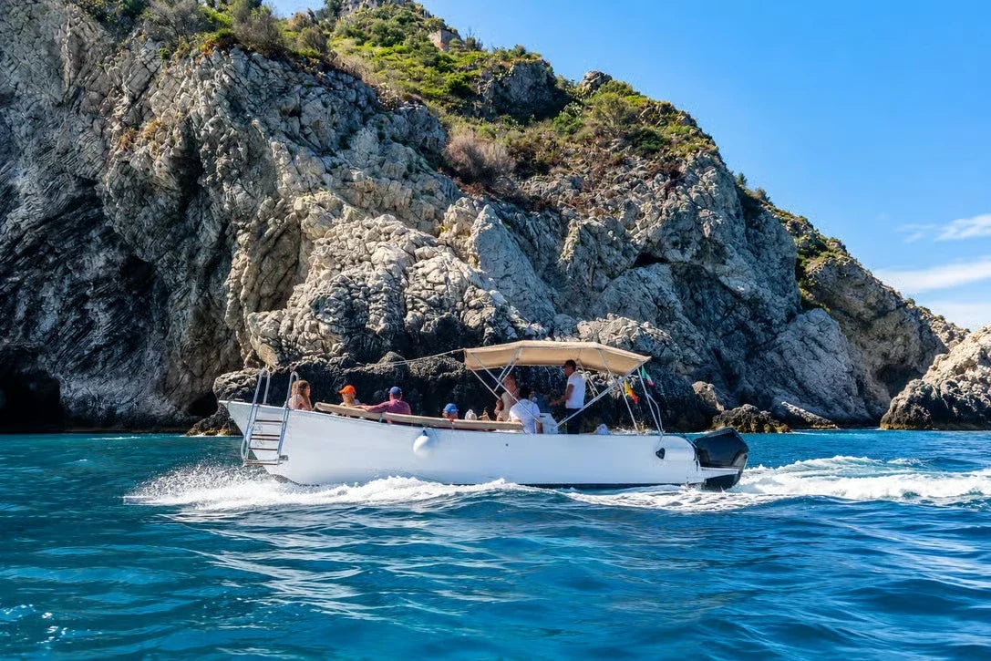 Boat cruising along the Taormina coastline on the Ionian Sea